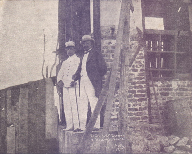 Na fotografia vê-se, da direita para a esquerda, o Marechal Hermes da Fonseca, o General Bento Ribeiro e o Dr. Augusto Ramos, no alto do Morro da Urca, em visita às obras do Caminho Aéreo do Pão de Açúcar.